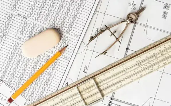 Traditional structural engineering technical drawing blueprint on a desk with a drafting compass, pencil, and eraser