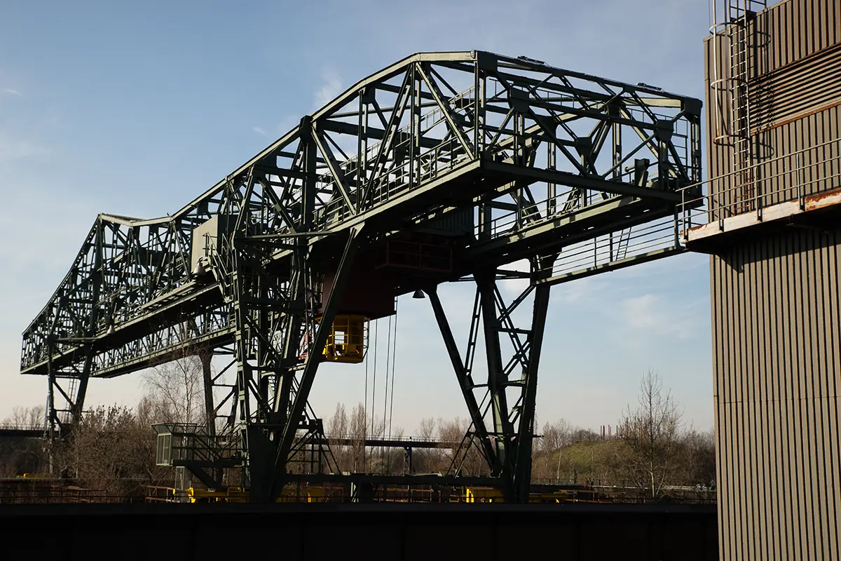 Heavy duty industrial steel truss gantry system and fabricated bridge infrastructure elements under a clear sky