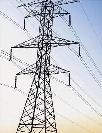 High-voltage steel lattice transmission tower with overhead power lines against a clear blue sky