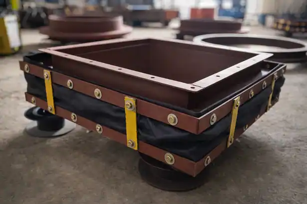 Industrial non-metallic flexible bellows component with a dark fabric layer and bolted steel flange