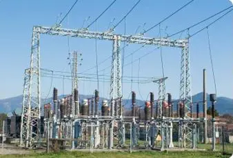 Compact outdoor electrical substation featuring overhead lattice gantry structures and transformer equipment mounts
