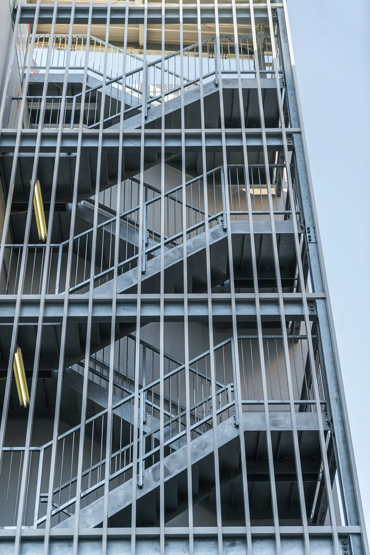 Multi-story modern building structure featuring prefabricated modular precast concrete beams and external steel staircases