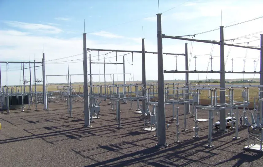 Gray steel support columns and portal frames installed in an outdoor power distribution switchyard