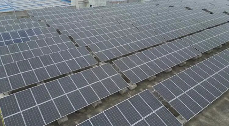 High-angle view of an extensive utility-scale rooftop solar panel installation featuring engineered structural support racking arrays